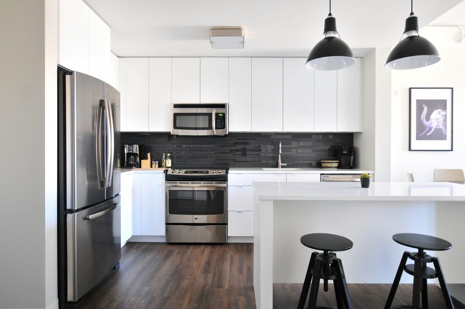 High-end kitchen with marble countertops, custom cabinetry, pendant lighting, and a central island featuring sleek bar stools. Designed with a blend of contemporary and traditional elements, showcasing the timeless elegance and luxury craftsmanship